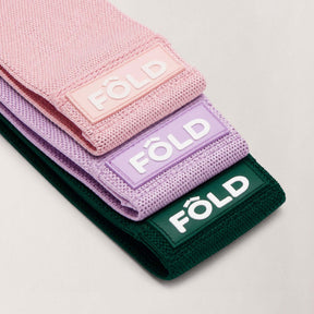Pilates Resistance Bands Bundle - Rose Pink, Thistle Purple, Forest Green showing three resistance bands in various colors.