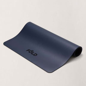 FOLD Reformer Pilates Mat - Navy displayed rolled out, designed for comfort and stability during workouts.