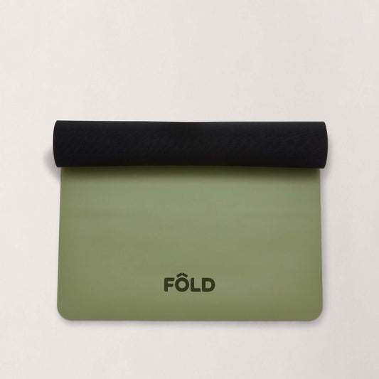FOLD Reformer Pilates Mat - Pistachio rolled with black matting, designed for comfort and stability in workouts.