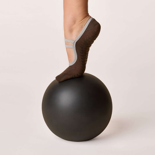 Ballet Grip Socks - Cocoa showcased on a foot balancing on a black exercise ball, highlighting non-slip design.