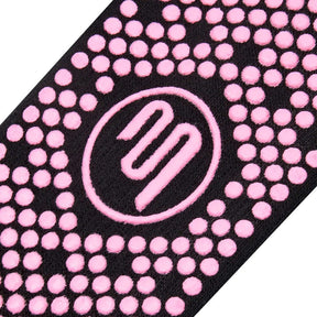 Close up of pink Pilates grip sole on black socks