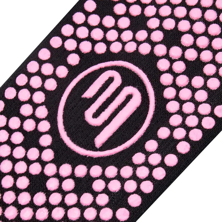 Close up of pink Pilates grip sole on black socks