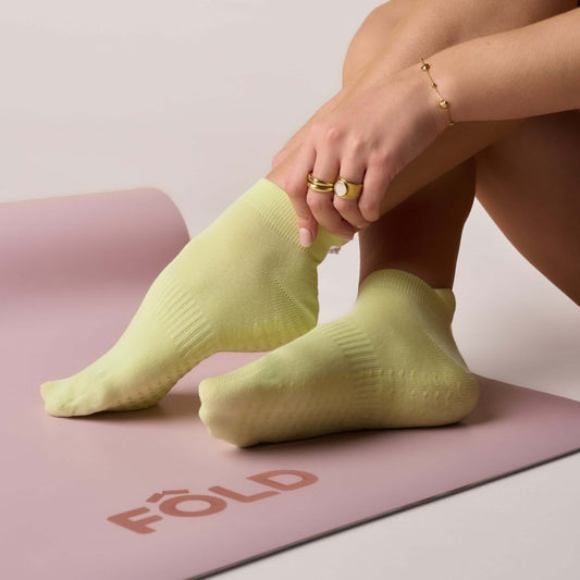 Pilates Low Rise Grip Socks - Lime worn during practice on a yoga mat, showcasing their comfort and style.